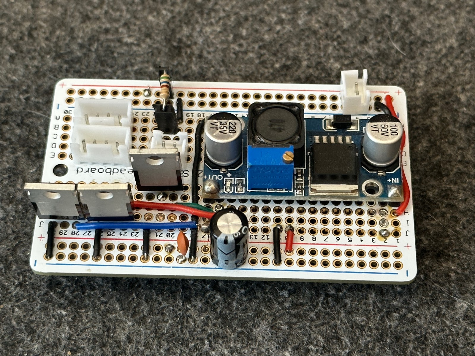 James's photo of the soldered perma-proto board with MOSFETs, capacitors, buck converter and white JST connectors.